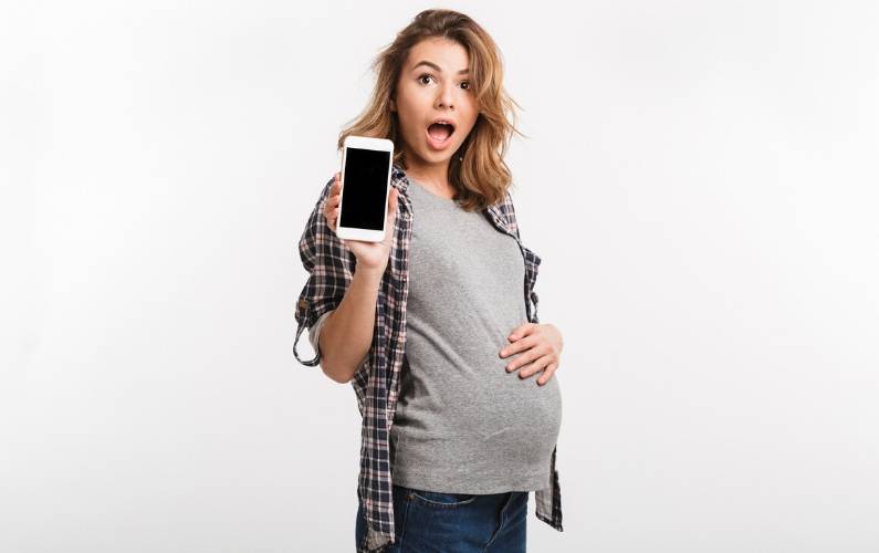 pregnant mom holding up a cell phone