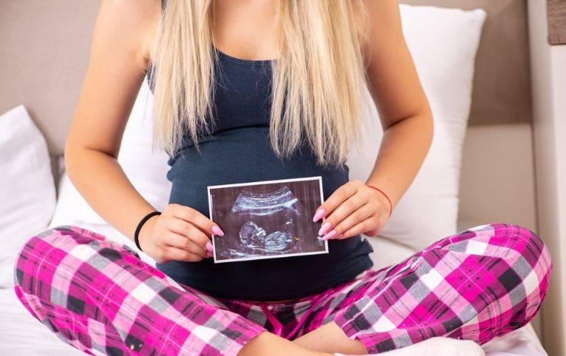 pregnant woman holding a ultrasound picture