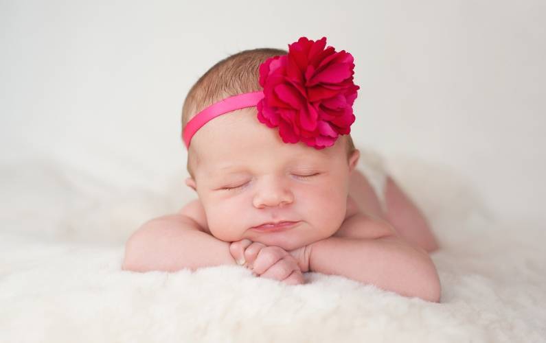 picture of cute newborn girl with a pink flower headband